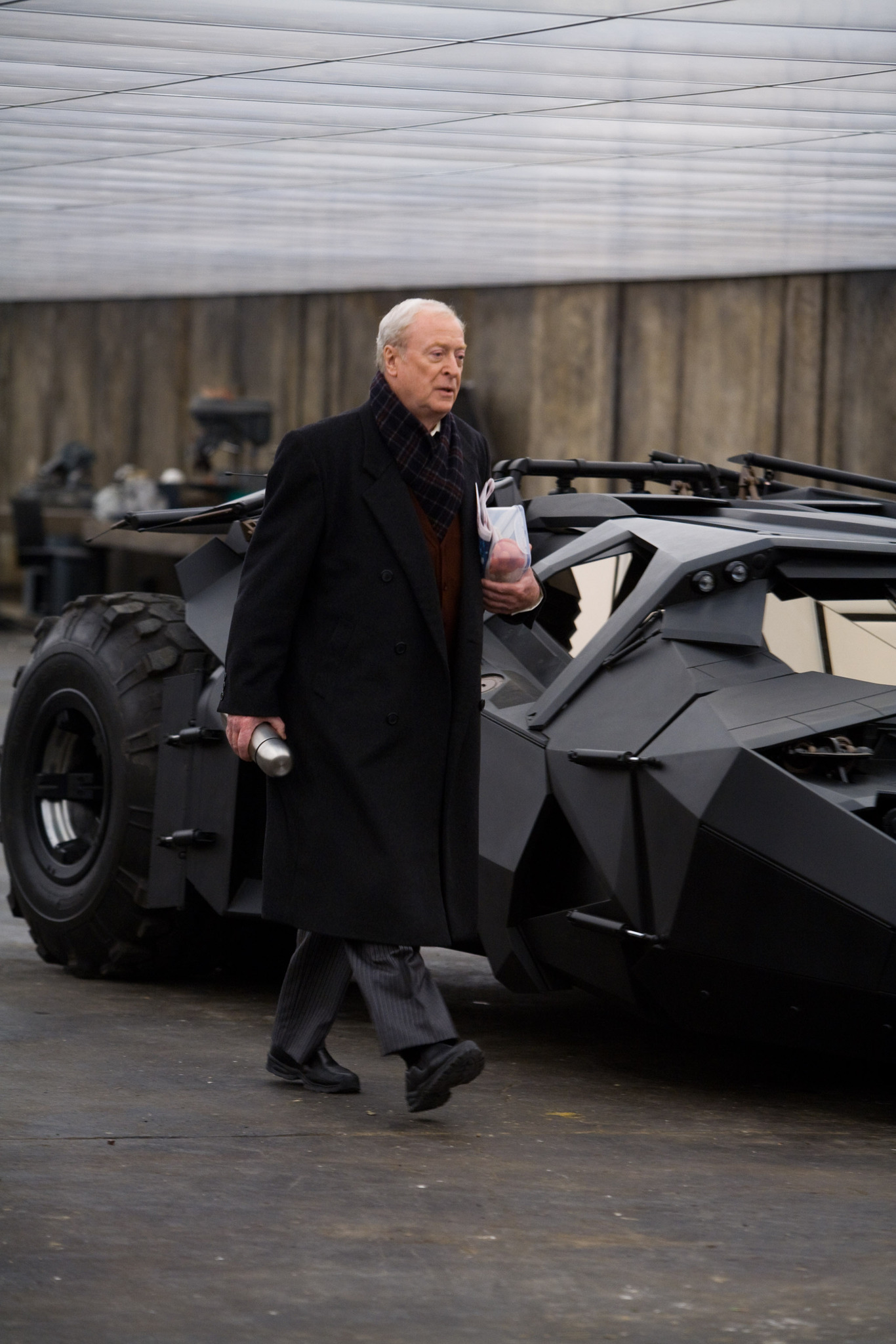 Michael Caine rushing past the Batmobile